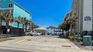 A hotel with a turquoise exterior, a gated parking area, and a sign for Crescent Sands. - 3 bedroom house in Crescent Beach. Pets/motorcycles allowed. (North Myrtle Beach)