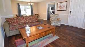 A living room with a sofa, armchair, coffee table, and a rug. - 3 bedroom house in Crescent Beach. Pets/motorcycles allowed. (North Myrtle Beach)