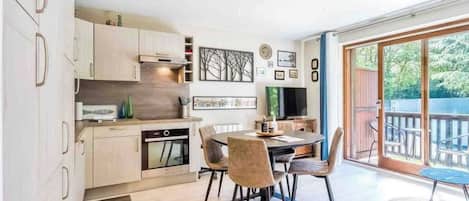 Una cocina moderna con armarios de madera y un comedor con una mesa redonda y sillas.