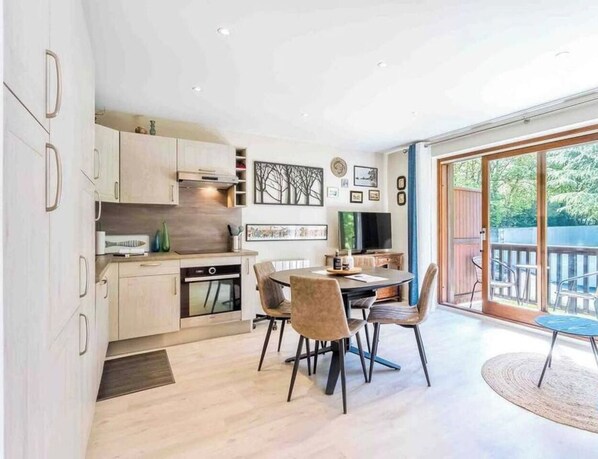 A modern kitchen with wooden cabinets and a dining area with a round table and chairs.