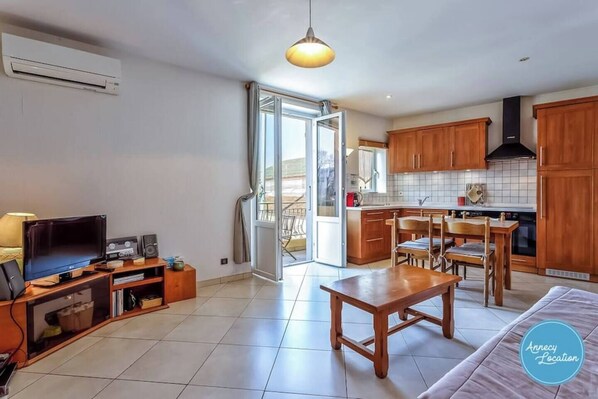 A modern apartment with a living room, kitchen, and balcony.