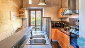 Une cuisine moderne avec des murs en bois, des appareils électroménagers en acier inoxydable et une grande fenêtre.