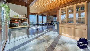 Un'ampia cucina con mobili in legno, un'area pranzo con sedie e un'ampia finestra con vista.