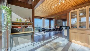 Un'ampia cucina con mobili in legno, un'area pranzo con sedie e un'ampia finestra con vista.
