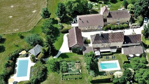 An aerial view of a large estate with two swimming pools, a tennis court, and a well-maintained garden. - Suite Familiale - Le Clos Vallis (Sarlat-la-Canéda)