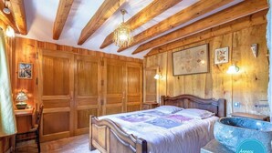 Ein Schlafzimmer mit Holzboden, einem Bett, einem Schreibtisch und einem Steinkonstruktion als Waschbecken.