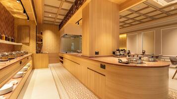 A modern kitchen with a central island, wooden cabinetry, and a herringbone-patterned floor.