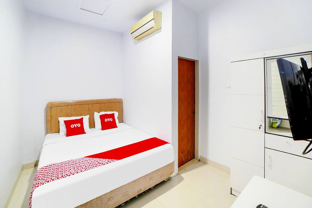 Ein Schlafzimmer mit einem Bett, einem Kleiderschrank und einer Klimaanlage.