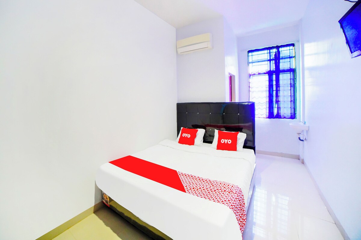 Un dormitorio con cama, ventana y aire acondicionado.