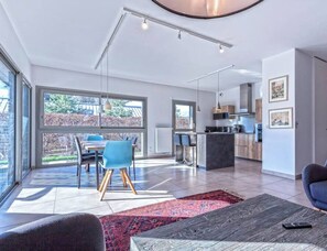 A modern interior with a dining area, kitchen, and living space.