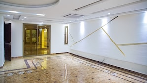 A spacious lobby with a marble floor, a glass door entrance, and a modern ceiling design. - Residence Ministre (Abidjan)