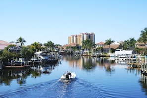 A marina with boats docked, a waterway, and residential buildings in the background.