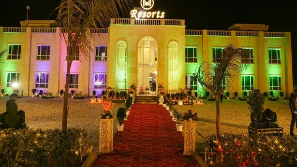 Un hôtel avec une entrée principale, de nombreuses fenêtres et une enseigne indiquant « Resorts ».