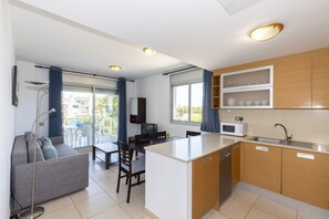 A compact kitchen with a dining area, a sofa, and a view of the outdoors. - Beachfront apartment with sea views - UHC PANORAMIC (Miami Playa)