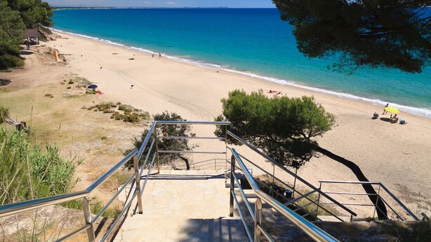 A beach with clear blue water, a sandy shore, and a staircase leading down to the beach. - Beachfront apartment with sea views - UHC PANORAMIC (Miami Playa)