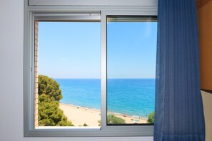 Une fenêtre donnant sur une plage et la mer.