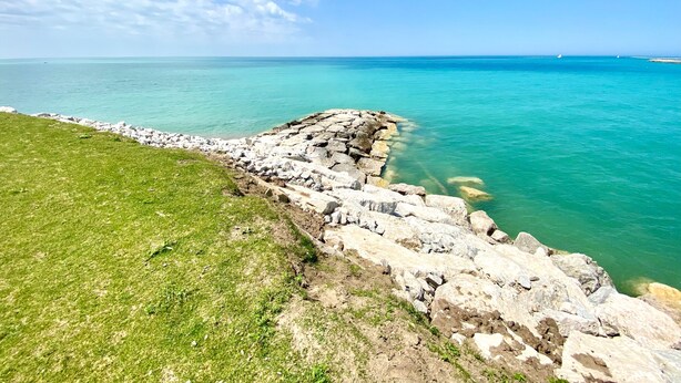 A coastal landscape with a grassy area and rocky shoreline leading to the sea. - KingBed,Sleeps10+,SmrtTV,BBQ,Gym,FireTable,FullKitchen. All in walking distance. (Goderich)
