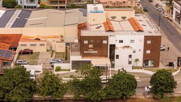 A hotel with a rooftop terrace, a parking area, and a street view.