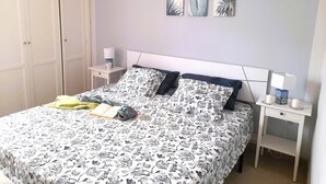A bedroom with a bed, bedside tables, a wardrobe, and wall art. - Lovely apartment Costa Adeje & Big Terrace (Costa Adeje)