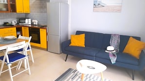 A compact living space with a kitchenette, a dining area, and a sofa with cushions. - Lovely apartment Costa Adeje & Big Terrace (Costa Adeje)