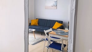 A room with a blue sofa, a small table, and a dining table with chairs. - Lovely apartment Costa Adeje & Big Terrace (Costa Adeje)