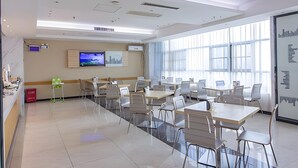A modern conference room with tables and chairs, a television, and a large window. - City Convenient Zhuzhou Sports Centre (Zhuzhou)