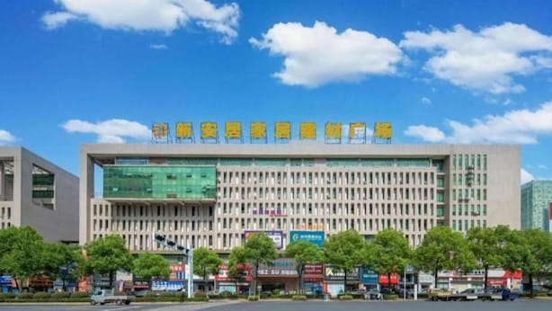 A modern building with a large glass facade and a sign with yellow characters. - City Convenient Zhuzhou Sports Centre (Zhuzhou)