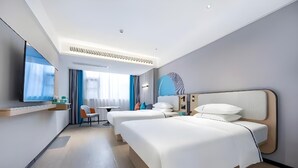 A modern hotel room with a large bed, a desk, and a chair. - City Convenient Zhuzhou Sports Centre (Zhuzhou)