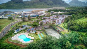An industrial area with a swimming pool, solar panels, and a large building. - Banyan Harbor #F71, Walk to Beach, Wifi, AC, Pool, Parking, Laundry (Lihue)