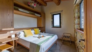 Un dormitorio con cama, mesita de noche y ventana con vistas.