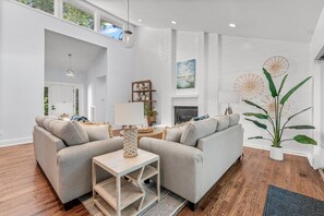 A modern living room with a sectional sofa, a small side table, and a potted plant.