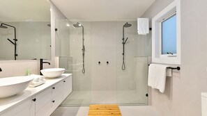 Een bad/douchecombinatie, een haardroger, handdoeken