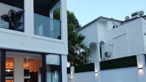 Et moderne hus i to etager med swimmingpool, liggestole og et godt oplyst interiør.