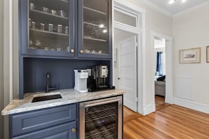 A kitchen with a built-in dishwasher, a coffee maker, and a wine cooler.