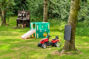 Children can play freely in this serene outdoor space surrounded by trees and grass.