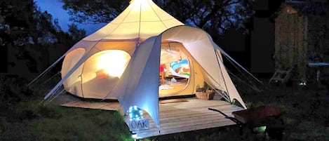 A dome-shaped tent with a wooden deck in front, labeled "OAK."