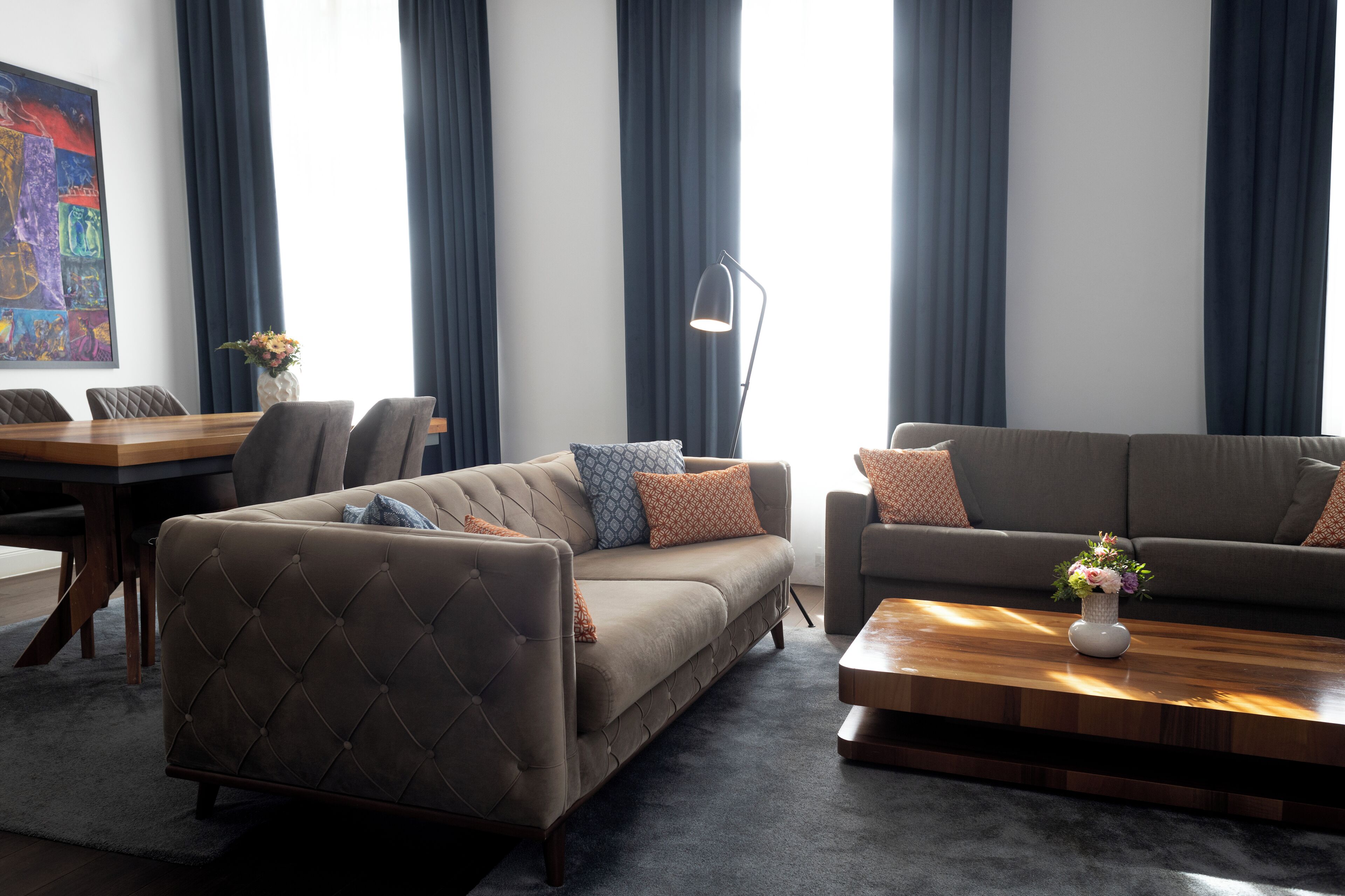 Ein modernes Wohnzimmer mit einer Couch, einem Couchtisch und einem Essbereich mit Tisch und Stühlen.