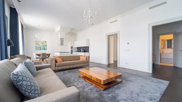 A modern living room with a sofa, coffee table, and a chandelier.