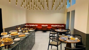 A modern restaurant with a marble counter, red seating, and pendant lighting. - ZOYA LUXURY RESIDENCE (Budapest)