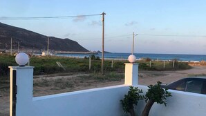 Ein Wohngebiet mit befestigter Auffahrt, einer weißen Mauer und Blick auf das Meer.