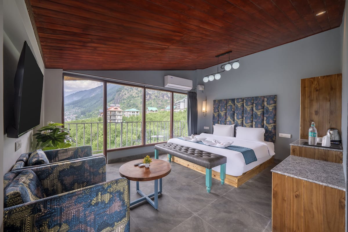 Un dormitorio con cama, sofá, mesa y televisión.