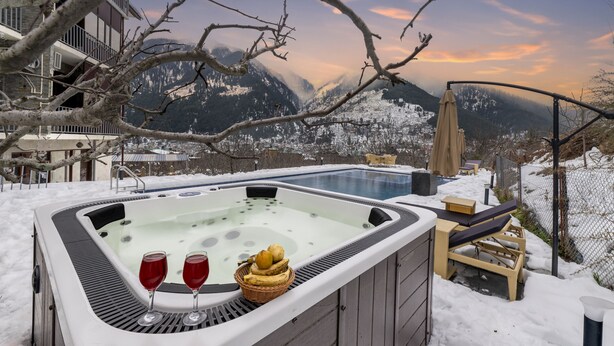 A hot tub with two glasses of red wine and a basket of apples, surrounded by snow and mountains. - Echor Himalayan Aurum Resort & Spa, Manali (Manali)