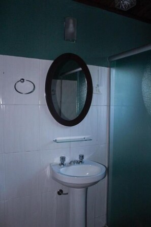A bathroom with a white sink, a mirror, and a towel ring. - Chalés Vista Linda (Santo Antonio do Pinhal)