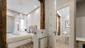 Un dormitorio moderno con una cama grande, un radiador y una pared de acento de madera.