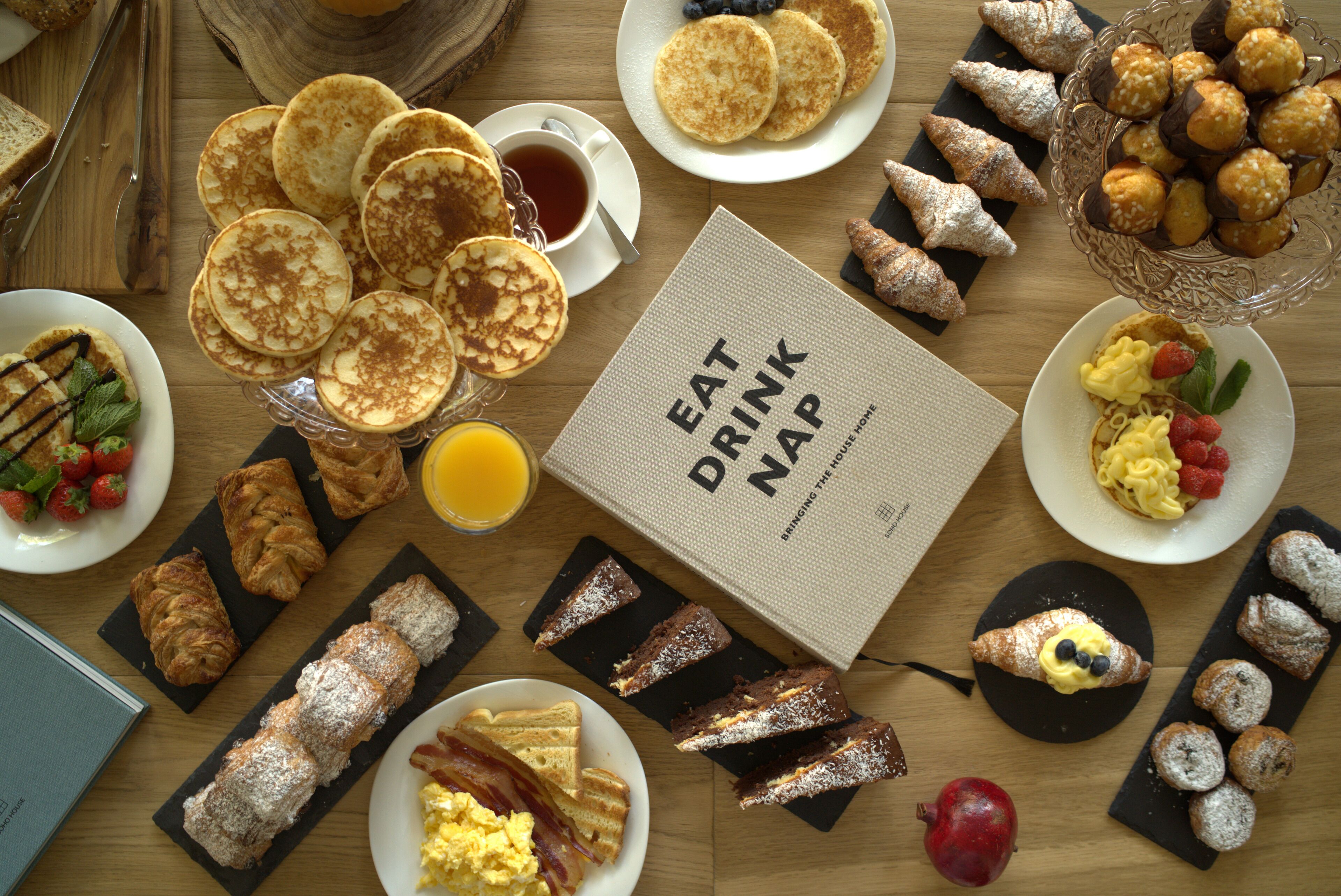A breakfast spread with pancakes, pastries, and a drink menu.