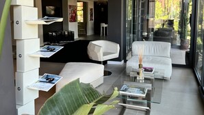 A modern living room with a glass coffee table, white sofas, and a large plant. -  M House Art Hotel (Cervia)