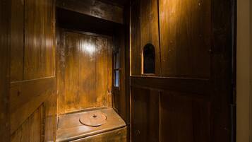 A wooden door with a small window and a round, flat object on a lower shelf.