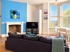 A living room with a fireplace, a television, and a sofa.