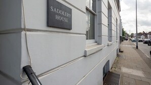 Een gebouw met een bord waarop 'SADDLERY HOUSE' staat.