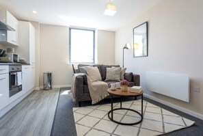 A modern living space with a sofa, coffee table, and a radiator.